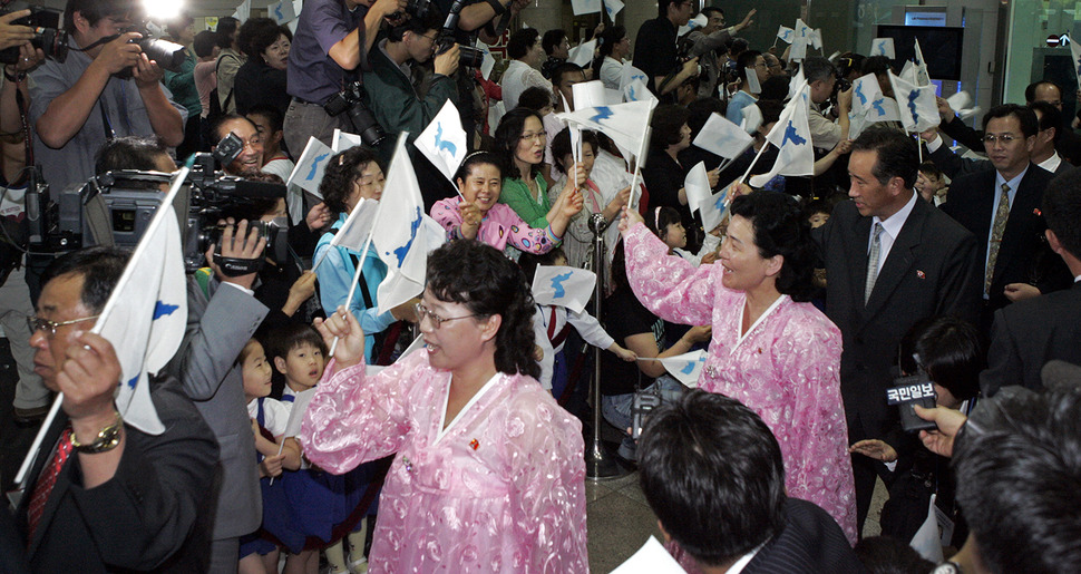 6.15공동선언발표 6돌 기념 민족통일대축전 참가를 위해 2006년 6월 14일 오전 고려항공 전세기편으로 광주에 도착한 북쪽 민간대표단이 한반도기를 흔들며 공항을 빠져나가고 있다. 6.15민족통일대축전은 17일까지 열린다. 광주/김정효 기자 hyopd@hani.co.kr