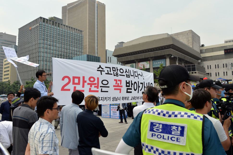 성남지역 학부모단체 등에 속한 시민들이 이재명 시장 단식농성을 비판하는 보수단체 회원들에게 “수고많으십니다~ 2만원은 꼭 받아가세요”라고 적힌 펼침막으로 맞불을 놓고 있다. 보수단체 어버이연합처럼 돈을 받고 나온 것은 아니냐는 뜻을 담은 것으로 보인다. 성남시 제공