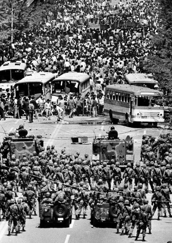 1980년 5월 21일 시민들이 전날 도청 앞 저지선을 뚫으려다 멈춘 버스를 바리케이드로 이용 계엄군과 대치하고 있다. 5·18재단(황종건) 제공