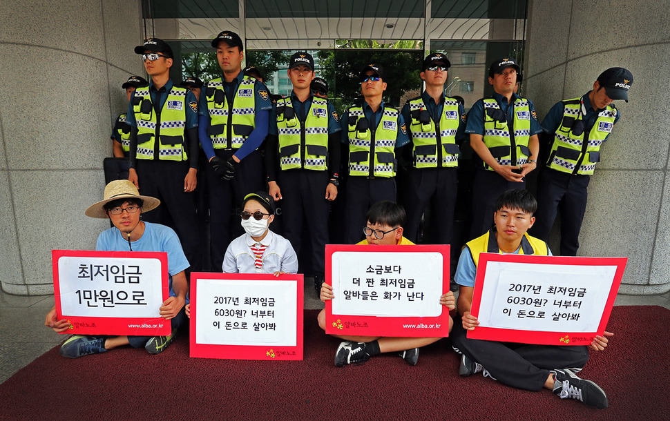 28일 오전 알바노조 조합원들이 서울 마포구 경총회관 앞에서 최저임금위원회에서 10년내 최저임금 동결을 주장한 경총을 규탄하는 기자회견을 마친 뒤 경총관계자 면담을 요청하며 이를 막는 경찰 앞에 앉아 있다. 김태형 기자 xogud555@hani.co.kr