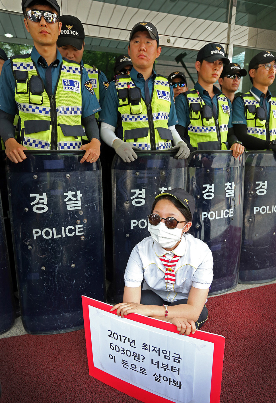 28일 오전 알바노조 조합원들이 서울 마포구 경총회관 앞에서 최저임금위원회에서 10년내 최저임금 동결을 주장한 경총을 규탄하는 기자회견을 마친 뒤 경총관계자 면담을 요청하며 이를 막는 경찰 앞에 앉아 있다. 김태형 기자 xogud555@hani.co.kr