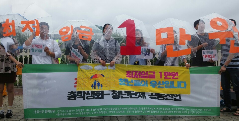 5일 여의도 국회의사당 정문 앞에서 전국 21개 대학 총학생회와 청년단체 청년하다가 ’최저임금 1만원’을 주장하는 성명을 발표한 가운데, 기자회견에 참여한 대학교 학생회장들이 ’최저 임금 1만원’이라고 쓰인 우산을 들고 최저임금 인상을 주장하는 퍼포먼스를 하고 있다. 고한솔 기자
