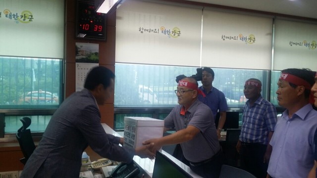 13일 오전 여용주(오른쪽)사드배치반대 음성군대책위원장이 음성군 주민 2만3095명이 서명한 사드 배치 반대 서명지를 국방부에 전달하고 있다.음성군청 제공