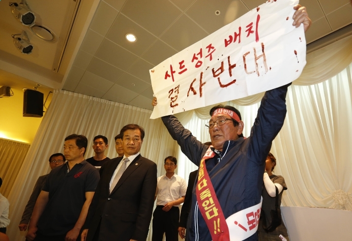 국방부가 사드 배치 지역으로 경북 성주가 확정됐다고 공식 발표한 직후인 13일 오후 서울 용산구 국방부 컨벤션센터에서 ‘사드 성주 배치 반대 범국민비상대책위원회’의 이재복 위원장이 ‘사드 성주 배치 결사반대’라고 쓴 혈서를 들고 항의하고 있다. 그 옆은 황인무 국방부 차관(넥타이 맨 이). 김봉규 선임기자 bong9@hani.co.kr