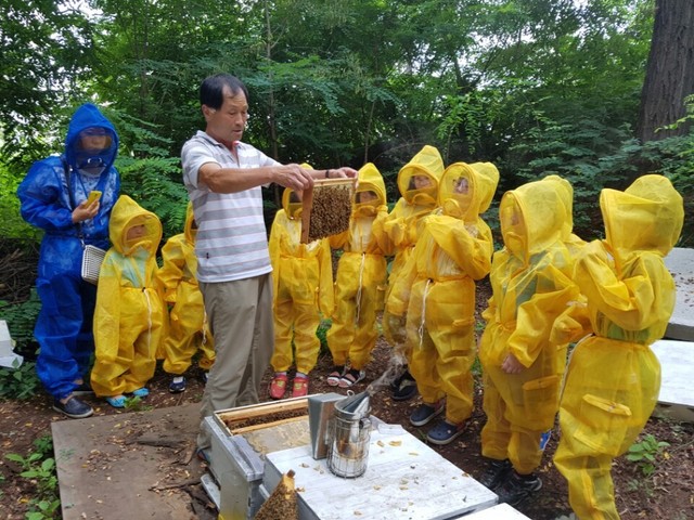 지난 21일 아이들이 서울시 광진구 광장동 자투리텃밭 옆 양봉장에서 원익진 (사)한국양봉협회 지회장(가운데)의 설명을 들으며 도시양봉을 체험하고 있다.