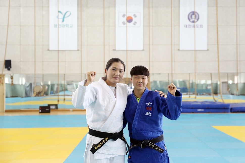 바르셀로나올림픽 유도 금메달리스트인 김미정(왼쪽) 용인대 교수가 25일 무도대학 4층 유도장에서 정아현과 다정하게 포즈를 잡고 있다.   월드비전 제공