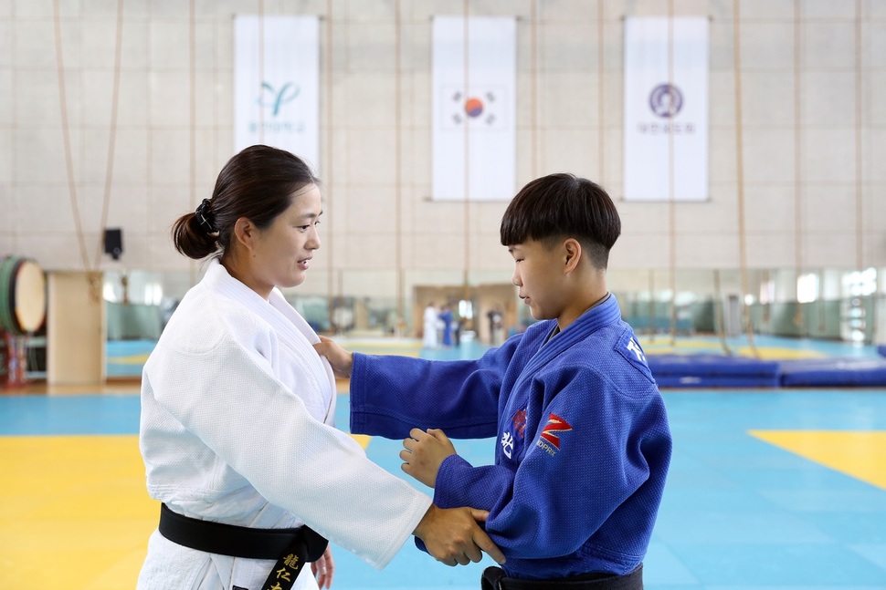 바르셀로나올림픽 유도 금메달리스트인 김미정(왼쪽) 용인대 교수가 25일 무도대학 4층 유도장에서 정아현에게 잡기 기술을 가르치고 있다.   월드비전 제공