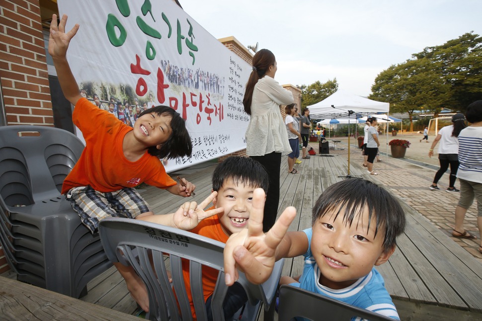 학부모들의 수화 공연이 펼쳐지는 동안 무대 한쪽에 엄마를 기다리며 앉아 있던 아이들이 카메라를 발견하자 장난스런 포즈를 취한다.