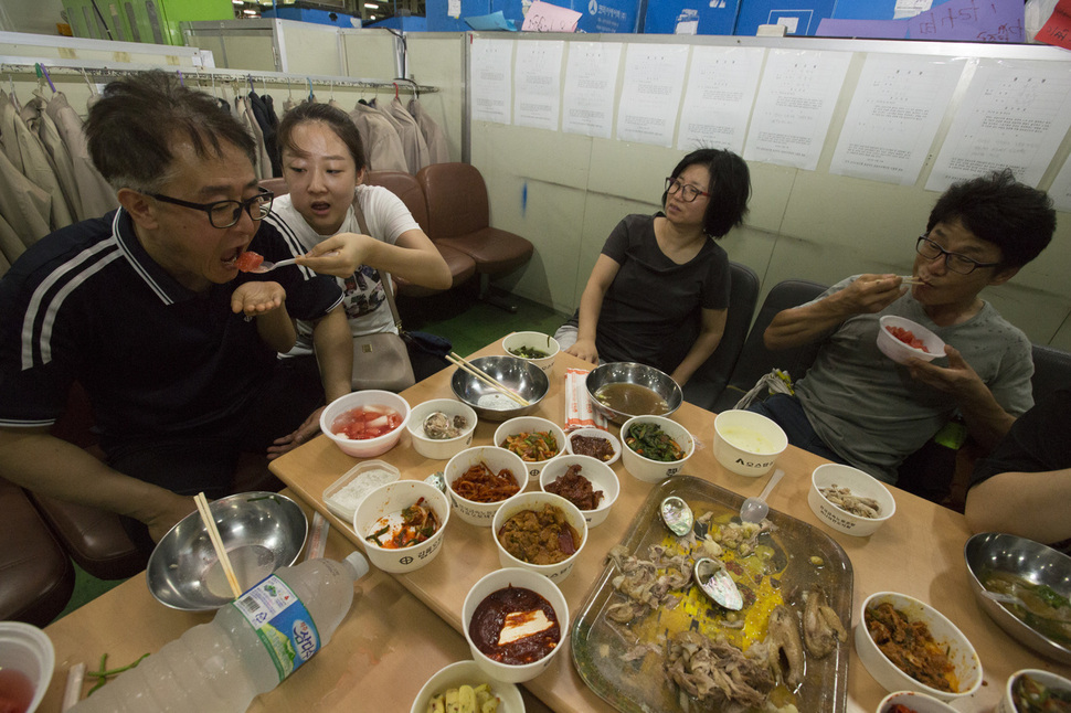불법 직장폐쇄 6일째인 31일 오전 충남 아산시 갑을오토텍 공장에서 이 회사의 한 직원이 딸이 주는 수박을 먹고 있다. 그는 이날 "사측에서 노조파괴를 위해 고용한 용역이 들어오면 몸으로 막아야만 하는데, 같이 폭력을 행사할 수 없어 맞기만 해야 한다. 떨린다"라고 말했다. 아산/김성광 기자 flysg2@hani.co.kr