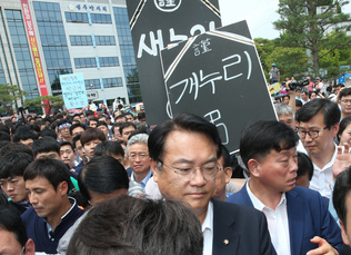 정진석 새누리당 원내대표 일행이 26일 낮 경북 성주군청 앞에서 주민 간담회를 마친 뒤 사드(THAAD·고고도미사일방어)체계 배치 지역 확정해 항의하는 주민들 손팻말 시위 속에 버스로 향하고 있다. 상주/강창광 기자 chang@hani.co.kr