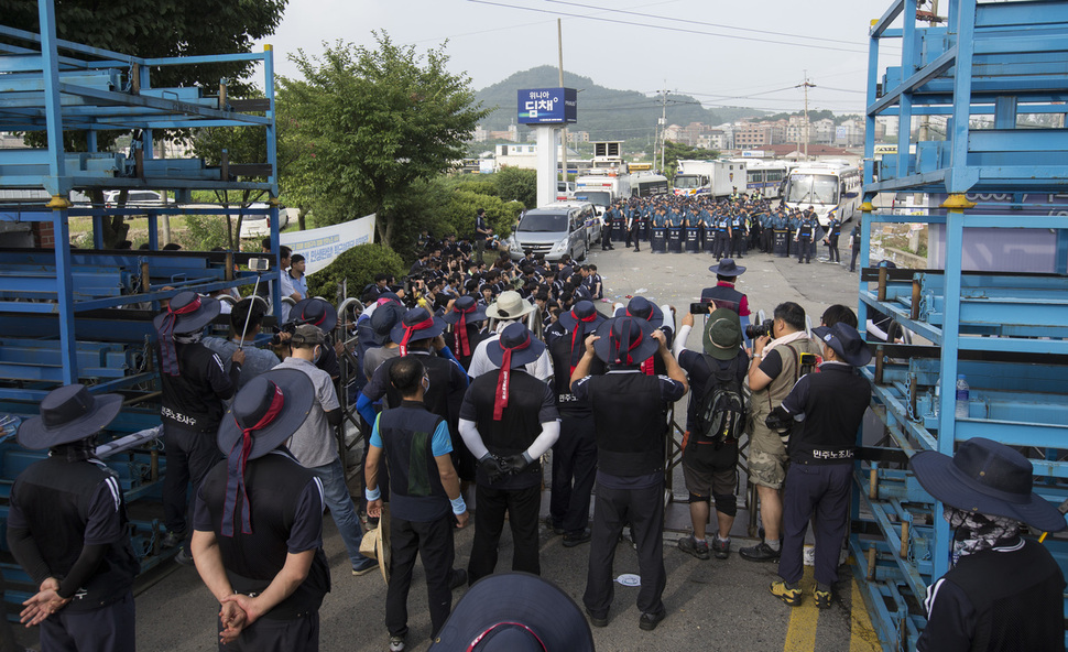 1일 오후 회사의 경비용역 투입이 예정돼있는 충남 아산 갑을오토텍 공장 입구에서 같은 날 오전 전국금속노조 충남지부 갑을오토텍지회 조합원들이 경찰, 이 회사 관리직 직원들과 대치하고 있다. 아산/김성광 기자 flysg2@hani.co.kr
