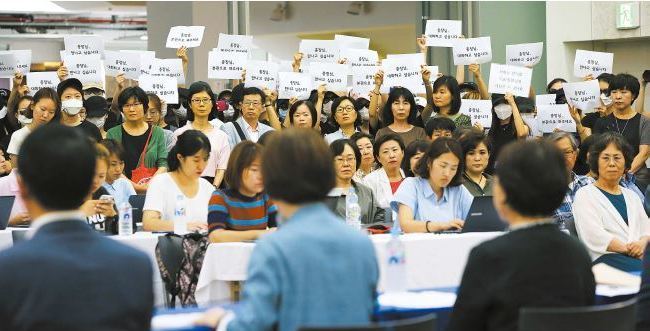 최경희 이화여대 총장(뒷모습 가운데)이 1일 오후 서울 서대문구 교내 이화캠퍼스복합단지(ECC)에서 평생교육 단과대 설립을 둘러싼 학내 사태와 관련한 긴급 기자회견을 하는 동안 학생들이 총장과의 대화를 요구하는 글귀가 적힌 종이를 들고 침묵시위를 벌이고 있다. 강창광 기자 chang@hani.co.kr