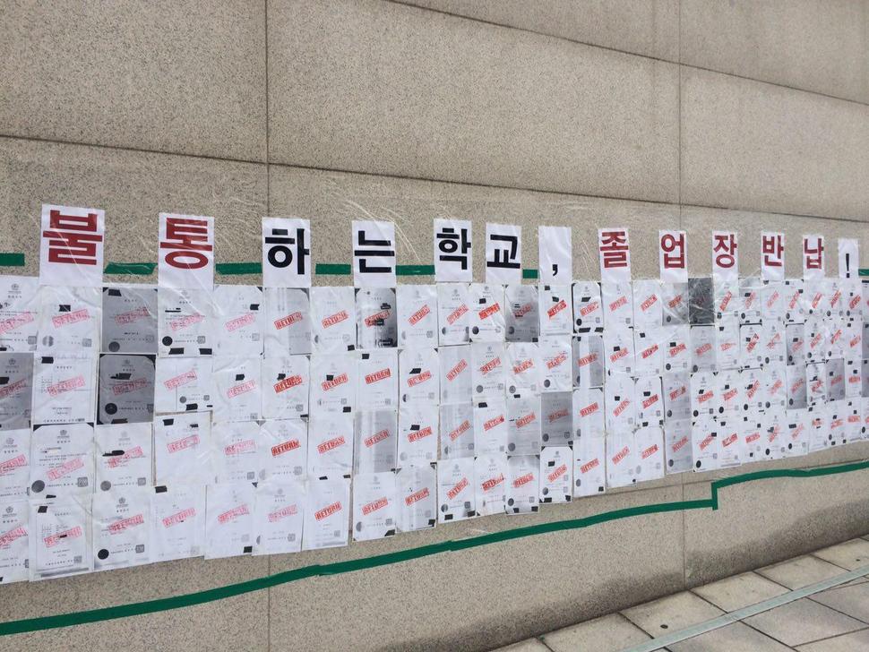 이화여자대학교에서 추진하려고 했던 평생교육 단과대학 지원사업인 ‘미래라이프 대학’ 설립을 반대하는 이화여대 학생들의 본관 점거농성 엿새째인 2일, 서울 서대문구 이화여대 정문 앞에는 졸업장 반납 시위를 준비하는 졸업장 복사본이 부착돼 있다. 본관으로 들어가는 이화캠퍼스복합단지(ECC)에는 포스트잇이 나붙었다. 농성 중인 학생들이 머무는 본관 앞에는 ‘최경희 총장님 대화하고 싶습니다’라는 펼침막이 붙고, 침묵만 감돌았다.