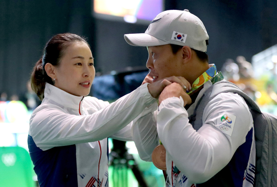 윤진희(왼쪽)가 8일(한국시각) 브라질 리우데자네이루 리우센트루 2관에서 열린 여자 역도 53㎏급 결승에서 동메달을 차지한 뒤 남편인 원정식 선수의 목에 동메달을 걸어주고 있다.