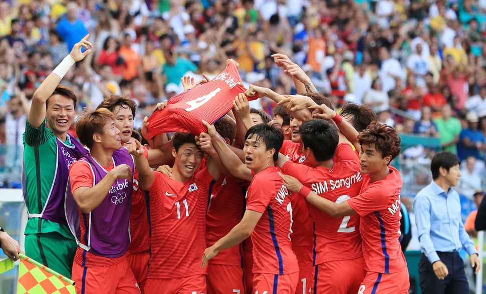 한국의 황희찬(11번)이 8일(한국시각) 브라질 사우바도르에서 열린 독일과의 2016 리우올림픽 남자축구 C조 2차전에서 선제골을 넣은 뒤 동료들과 함께 이번 대회 결장한 송주훈의 4번 유니폼을 들고 세리머니를 하고 있다. 일본 J리그 미토 홀리호크에서 뛰는 송주훈은 대표팀 소집 직전 발가락 부상으로 제외됐다.   사우바도르/올림픽사진공동취재단