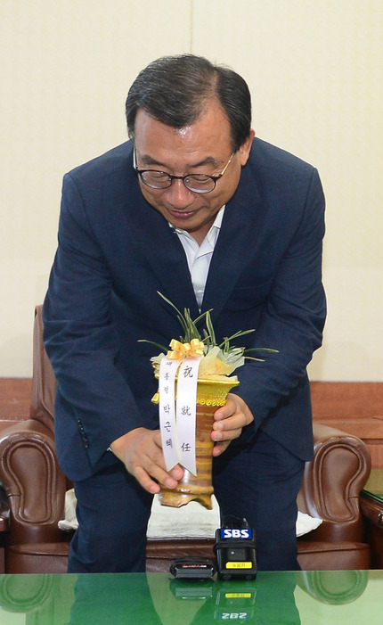 10일 이정현 새누리당 대표가 서울 여의도 당사 대표실에서 김재원 청와대 정무수석이 들고 온 박근혜 대통령의 축하 난을 탁자 위에 내려놓고 있다. 공동취재사진