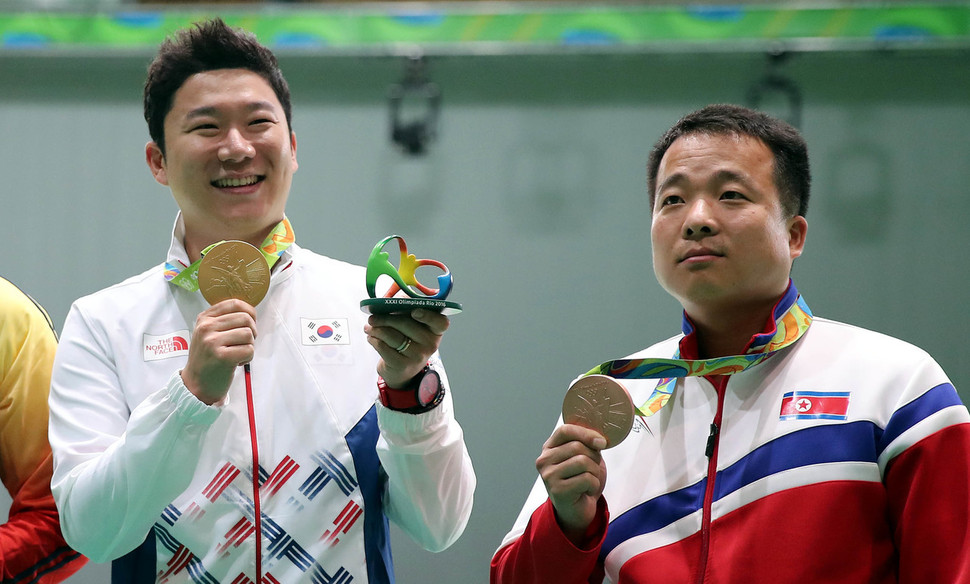 북한 김성국(오른쪽)이 10일 오후(현지시각) 브라질 리우데자네이루 데오도루 올림픽 사격센터에서 열린 남자 50m 권총 시상식에서 은메달을 들어보이고 있다. 옆에는 금메달을 차지한 진종오. 리우데자네이루/올림픽사진공동취재단