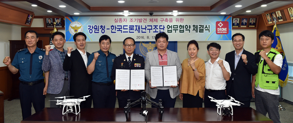 이중구 강원지방경찰청장(가운데 안경 쓴 사람)과 김정헌 한국드론재난구조단 대표가 17일 오후 강원지방경찰청에서 ‘무인비행장치(드론)를 활용한 실종자 수색 업무지원 협약’을 했다.  강원지방경찰청 제공