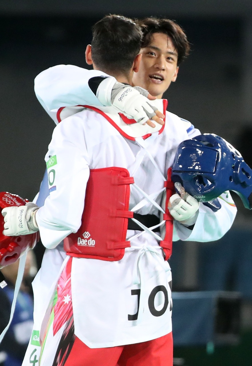 이대훈이 19일(한국시각) 브라질 리우데자네이루 바하 카리오카 경기장 3관에서 열린 남자 68kg급 8강전에서 진 뒤 요르단의 아흐마드 아부가우시에게 대인배처럼 진심어린 축하를 해주고 있다. 리우데자네이루/연합뉴스