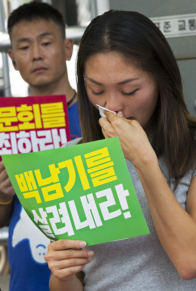 23일 강신명 경찰청장의 이임식이 열린 서울 서대문구 경찰청 앞에서 백남기 대책위 관계자들이 기자회견도중 흘린 눈물을 닦고 있다. 김성광 기자 flysg2@hani.co.kr