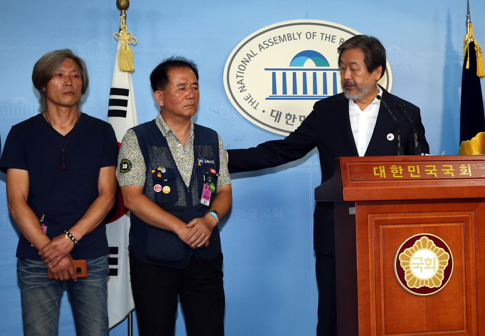 김무성 전 새누리당 대표(오른쪽)가 26일 오전 국회 정론관에서 기자회견을 열어 “강성노조 때문에 기타 제조업체 콜트악기가 망가졌다”는 1년 전 자신의 발언에 대해 공개사과한 뒤 방종운 콜트악기 지회장(가운데)을 발언대로 안내하고 있다. 제일 왼쪽은 이인근 콜텍 노조 지회장이다. 강창광 기자 chang@hani.co.kr