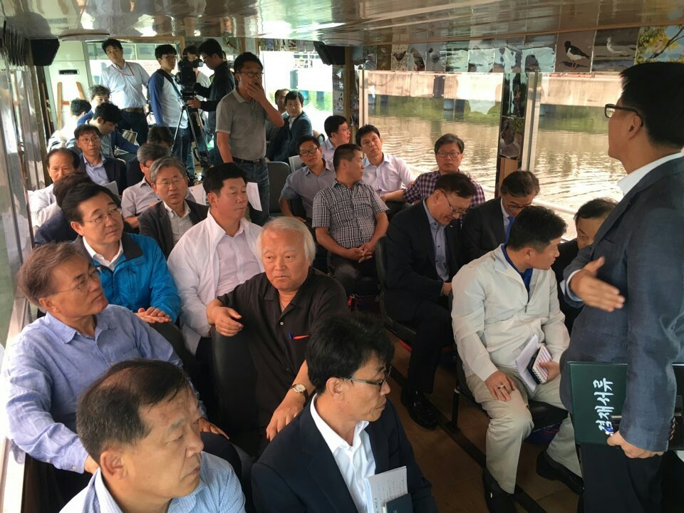 30일 부산·경남 더민주 국회의원들과 문재인 전 더민주 대표, 정부 관계자 등이 낙동강 하류를 둘러보기 위해 배에 올라 관계자의 설명을 듣고 있다. 더민주 부산시당 제공
