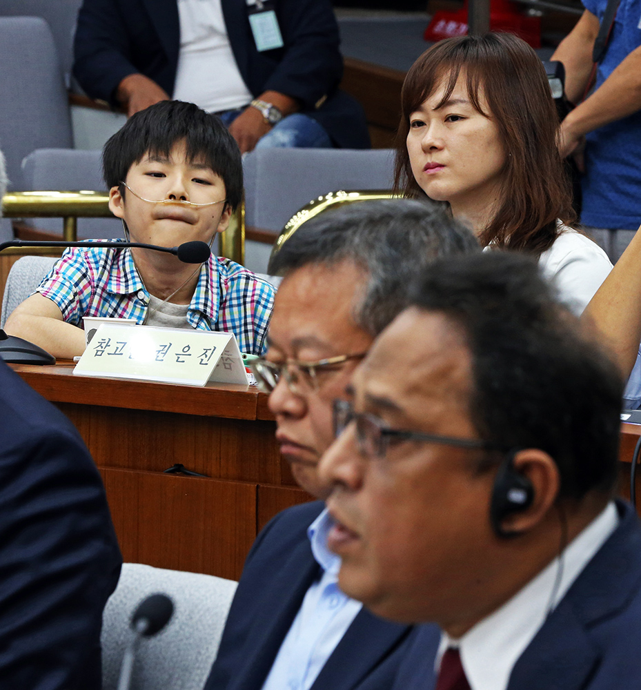 아타 샤프달 옥시 대표가 29일 오전 국회에서 열린 ‘가습기 살균제 사고 진상규명과 피해구제 및 재발방지 대책 마련을 위한 국정조사 특별위원회’ 청문회에 출석해 의원들의 질의에 답하는 모습을 참고인으로 출석한 가습기 피해자 어린이와 엄마가 지켜보고 있다. 강창광 기자 chang@hani.co.kr