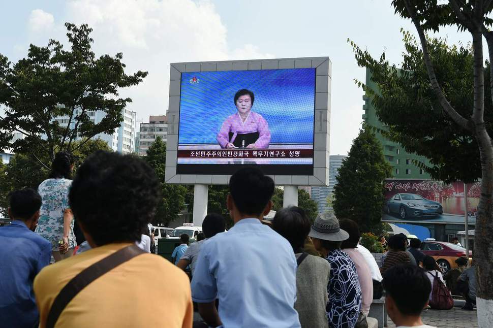 평양 시민들이 9일 평양역 앞에서 대형 티브이(TV) 화면을 통해 북 당국이 핵시험에 성공했다는 내용의 뉴스를 시청하고 있다. 평양/AFP 연합뉴스