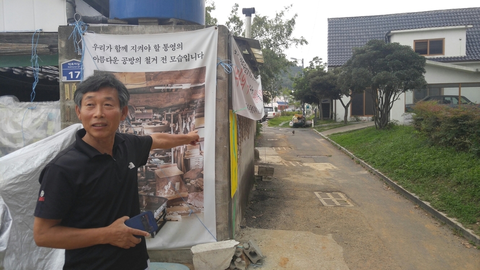 추용호 장인이 지난 16일 통영시 도천동 자신의 공방과 오른쪽 윤이상기념관 사이 골목길 안쪽으로 보이는 근린공원이 최근 통영시가 제안한 공예전수관 신축 자리라고 설명하고 있다.