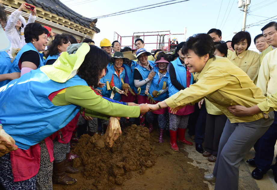 박근혜 대통령이 20일 오후 경북 경주시 황남동 고도한옥보존육성지구 안 지진피해 지역을 방문해 주민들을 위로하며 손을 잡고 있다. 박 대통령이 진흙을 밟지 않도록 경호원이 붙잡고 있다. 청와대는 21일 “주민들이 복구용 흙이니 밟지 말라고 요청해 멀리 떨어져 악수하던 상황”이라고 밝혔다. 경주/청와대사진기자단
