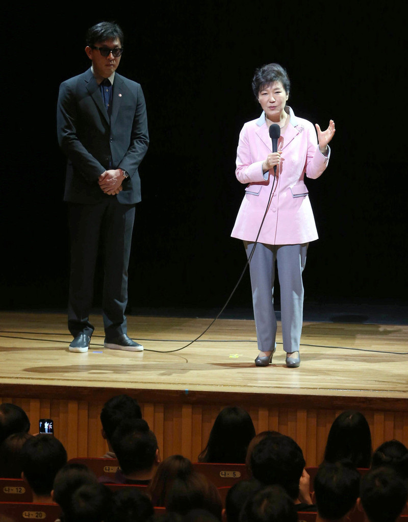 2014년 8월, 박근혜 대통령이 ‘문화가 있는 날' 행사의 일환으로 서울 종로구 상명대학교 상명아트센터에서 열린 융복합 공연 '하루(One Day)'를 관람하기에 앞서 무대에 올라 인사를 하고 있다. 왼쪽은 차은택 공연 총감독. 연합뉴스