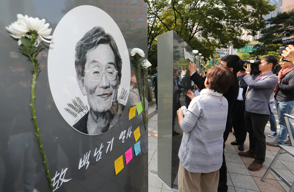 고 백남기 농민이 경찰 물대포에 쓰러진 종각 앞에 고인을 애도하는 ‘추모의 벽’이 세워졌다. 시민사회단체연대회의가 12일 오전 서울 종로구 종각 앞에 설치한 추모의 벽에 관계자와 시민들이 국화와 추모 내용을 적은 종이를 붙이고 있다. 추모의 벽은 일본대사관 앞 ‘평화의 소녀상’을 만든 김서경, 김운성 작가 부부가 제작했다. 김정효 기자 hyopd@hani.co.kr