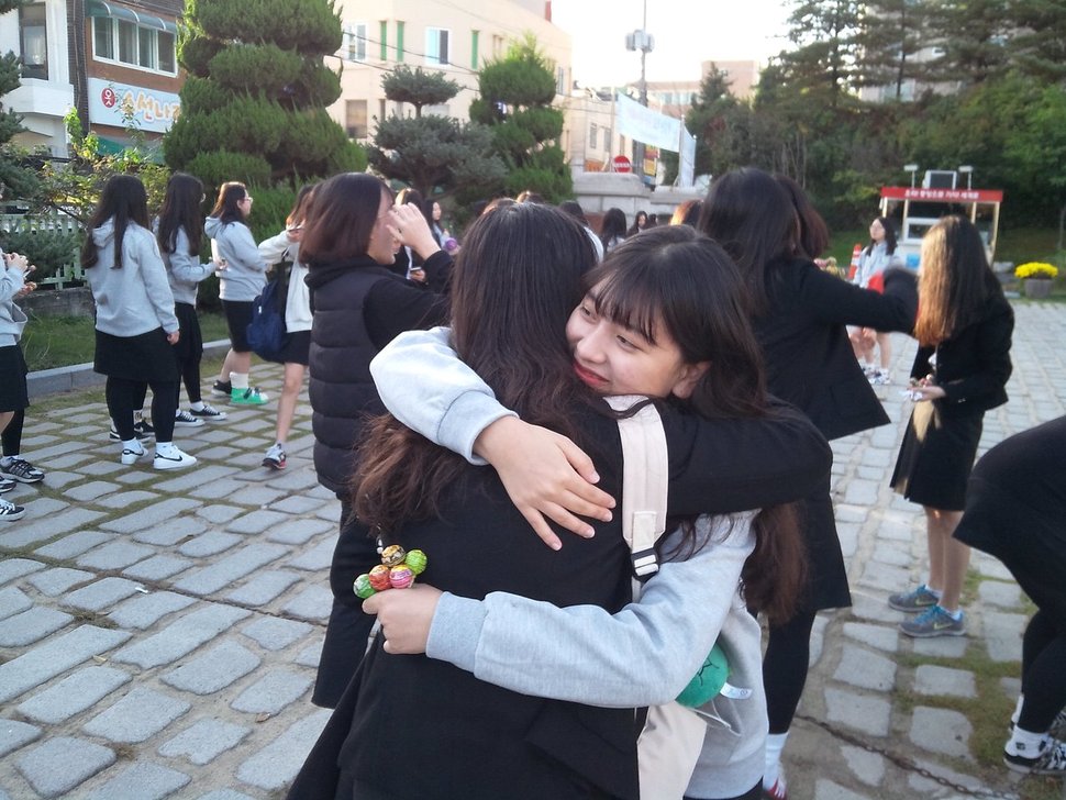 ‘사과데이’ 인 24일 충북 청주중앙여고 학생들이 아침 등굣길에 사랑의 포옹 캠페인을 하고 있다.충북교육청 제공