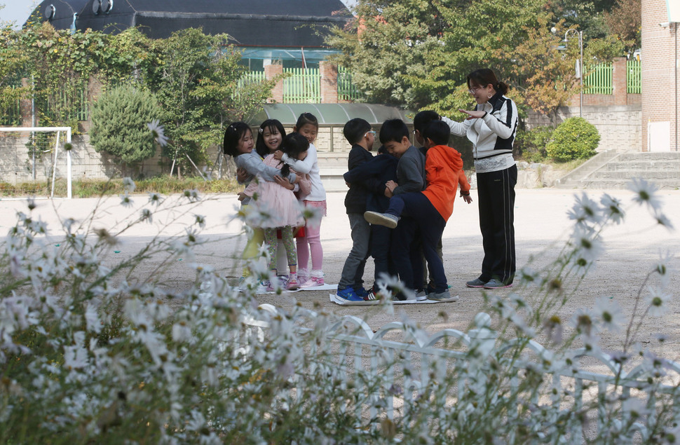 서울 강서구 개화초등학교 1학년 2반 학생들이 지난달 18일 학교 운동장에서 체육시간 도중 신문지 위에 올라가기 놀이를 하고 있다. 이 반 학생은 9명이 전부다. 신소영 기자 viator@hani.co.kr