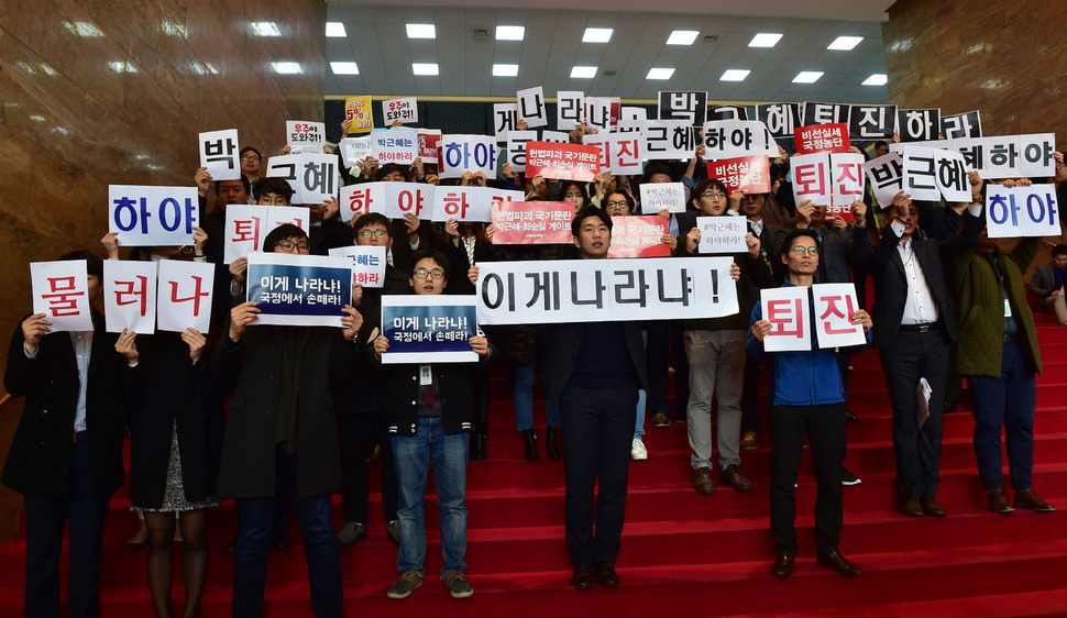 박근혜 대통령이 8일 국회를 방문해 정세균 국회의장과의 면담을 갖는 가운데 야당 당직자들이 박 대통령의 퇴진을 요구하는 피켓을 들고 구호를 외치고 있다. 사진 공동취재단.