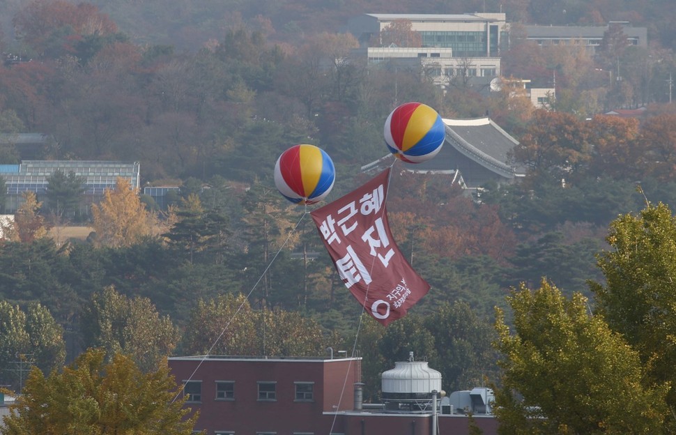 11일 오전 환경운동연합이 청와대 방향을 향해 박근혜 퇴진이라고 적은 현수막을 에드벌룬에 묶어 띄우고 있다. 현수막 뒤로 춘추관이 보이고 있다. 신소영 기자 viator@hani.co.kr