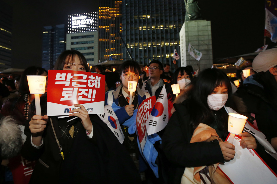 12일 저녁 서울 광화문광장에서 열린 3차 민중총궐기대회에서 교복을 입고 참석한 청소년들이 태극기와 촛불을 흔들며 박근혜 대통령 퇴진을 촉구하고 있다.  이정아 기자 leej@hani.co.kr