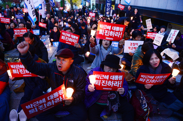 16일 오후 서울 서초구 서울중앙지검 앞에서 열린 박근혜 대통령 엄정수사 촉구 번개촛불집회에서 참석자들이 ‘박근혜 대통령 퇴진하라!’라고 쓰인 손팻말을 들고 구호를 외치고 있다. 연합뉴스