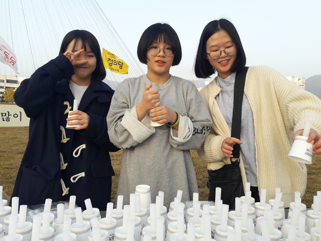 19일 창원광장에서 열린 경남시국대회에 참가했다, 종이컵에 초를 끼워 참가자들에게 나눠주는 자원봉사를 한 창원여중 1학년 3총사. 왼쪽부터 강주연, 윤지회, 김지호양.