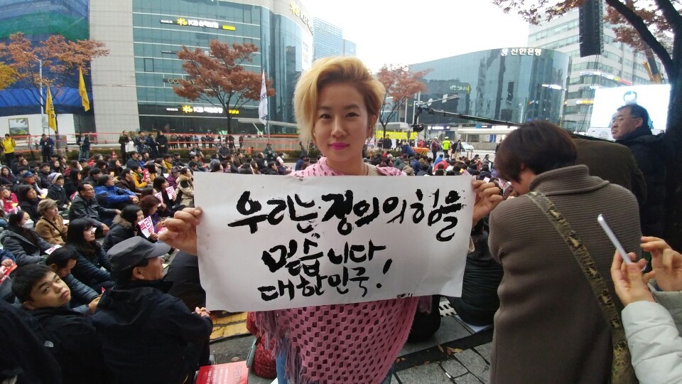 19일 대전 둔산동 갤러리아타임월드 앞에서 열린 ‘박근혜 퇴진 대전 10만 시국대회’에 참석해 붓글씨 퍼포먼스를 펼친 조서연(32)씨가 이날 자신이 쓴 글귀 중 하나를 들어 보이고 있다.