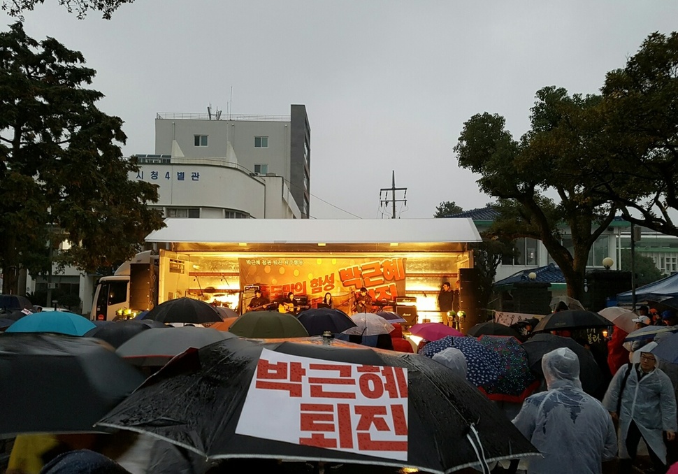 26일 오후 제주시청 앞 도로에서 열린 박근혜 퇴진을 촉구하는 제6차 제주도민 촛불집회에 참가한 사람이 우산에 ‘박근혜 퇴진’ 손팻말을 붙여 놓았다.