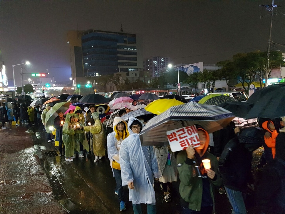 26일 오후 제주시청 앞 도로에서 열린 제6차 제주도민 촛불집회에 참가한 시민·학생들이 우산을 들거나 비옷을 입고 인근 대학로를 돌며 ‘박근혜 퇴진’ 등을 요구했다.