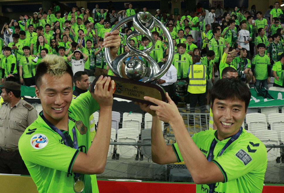 26일 오후(현지시각) 아랍에미리트 알아인 하자 빈 자예드 스타디움에서 열린 아시아축구연맹(AFC) 결승 2차전을 승리하며 우승을 차지한 전북 현대 김신욱(왼쪽)과 이동국이 트로피를 들고 팬들과 함께 기념촬영을 하고 있다.알아인/연합뉴스