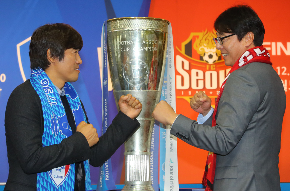 2016 축구협회(FA)컵 우승컵을 사이에 두고 서정원 삼성 감독(왼쪽)과 황선홍 FC서울 감독이 대결 자세를 취하고 있다.  연합뉴스