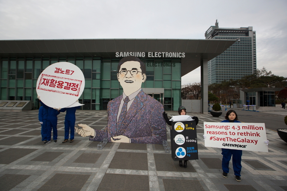 지난달 22일 국제환경단체 그린피스 활동가들이 경기 수원시 삼성전자 본사 앞에서 권오현 삼성전자 대표의 얼굴을 형상화한 대형 조형물을 설치하고 그 옆에 “재활용 결정”이라는 문구가 쓰인 말풍선을 들고 있다. 사진 그린피스 제공