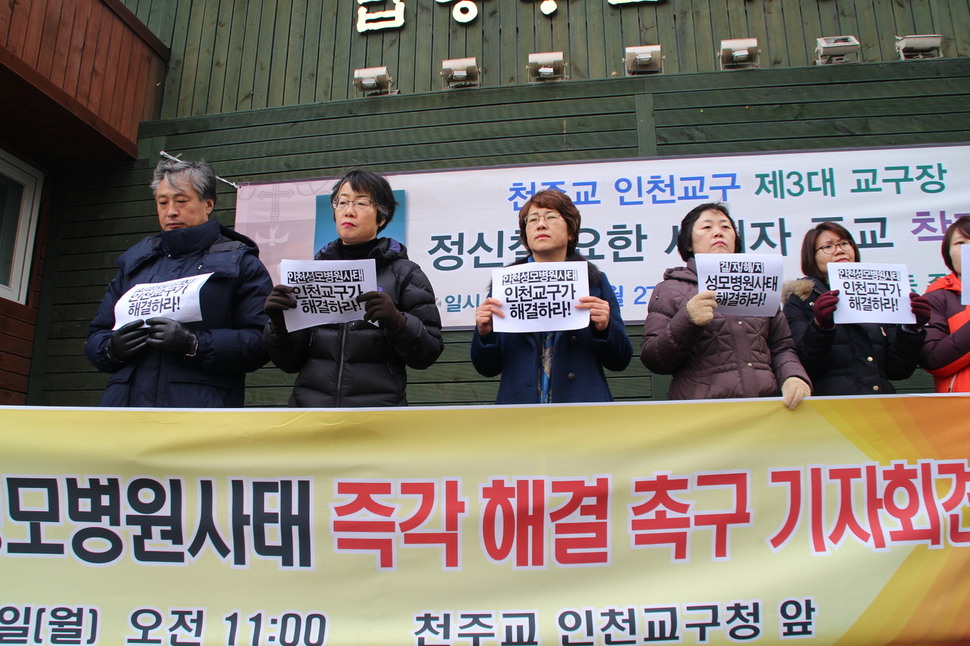 5일 인천 답동성당 입구에서 ‘인천성모·국제성모병원 정상화를 바라는 인천시민대책위원회’ 관계자들이 ‘인천성모병원사태 천주교 인천교구가 결자해지 차원에서 해결하라'고 적힌 힌 종이를 들고 병원 재단인 천주교 인천교구에 사태해결을 촉구하고 있다.