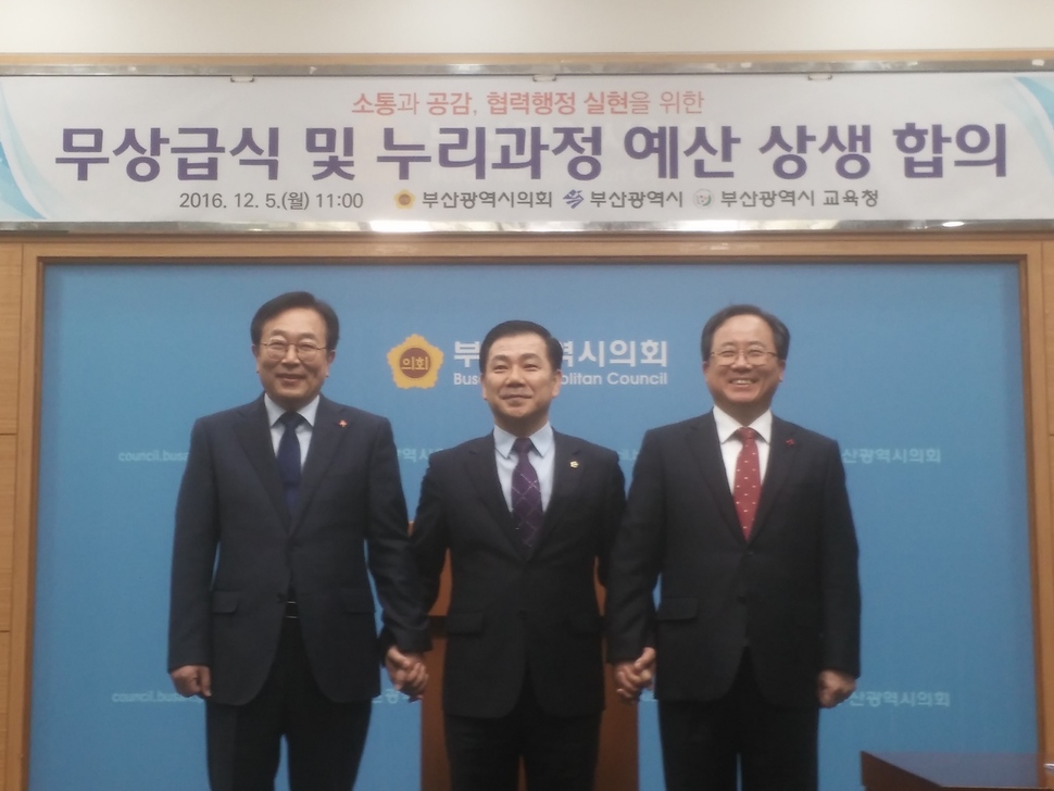 서병수 부산시장(왼쪽부터)·백종헌 부산시의회 의장·김석준 부산시교육감이 내년부터 중학교 무상급식 시행을 알리는 기자회견을 연 뒤 손을 잡고 있다.