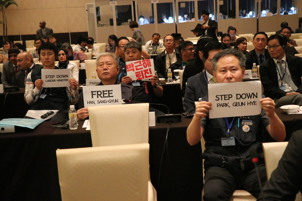 7일 오후 인도네시아 발리에서 열린 국제노동기구(ILO) 아시아태평양 총회에서 한국노총과 민주노총 참석자들이 박근혜 대통령·이기권 고용노동부 장관 퇴진과 한상균 민주노총 위원장 석방을 요구하는 피켓을 들고 있다. 한국노총 제공