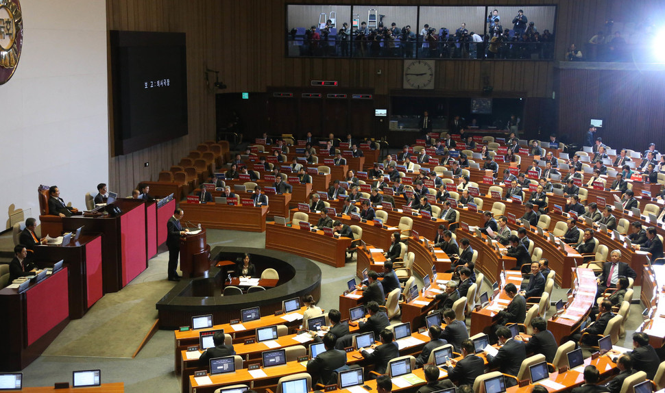 권영진 국회 의사국장이 8일 오후 국회 본회의에서 `박근혜 대통령 탄핵소추안'을 보고하고 있다. 더불어민주당 의원들은 의석 모니터에 탄핵 가결을 촉구하는 팻말을 걸어두었다. 이정우 선임기자 woo@hani.co.kr