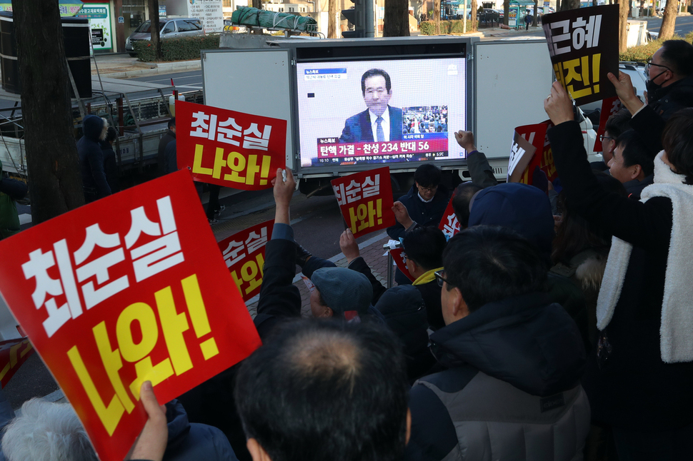 ‘박근혜 정권 퇴진 광주시민운동본부’ 회원들이 9일 오후 광주 북구 중흥동 새누리당 광주시당 앞에서 국회의 대통령 탄핵 가결 소식을 방송중계로 지켜보며 환호하고 있다. 광주/연합뉴스